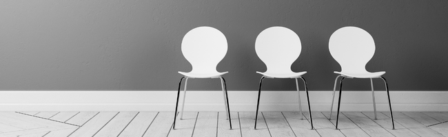 Cadeiras vazias em um ambiente corporativo, representando ausências de colaboradores e absenteísmo no trabalho.